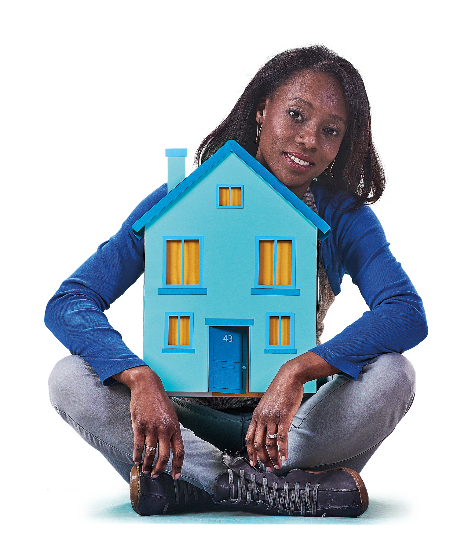 Image of a woman wearing blue sat cross-legged hugging a big blue house 