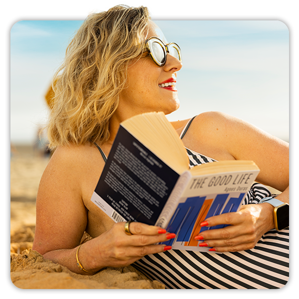 close up image of a  woman reading on the beach