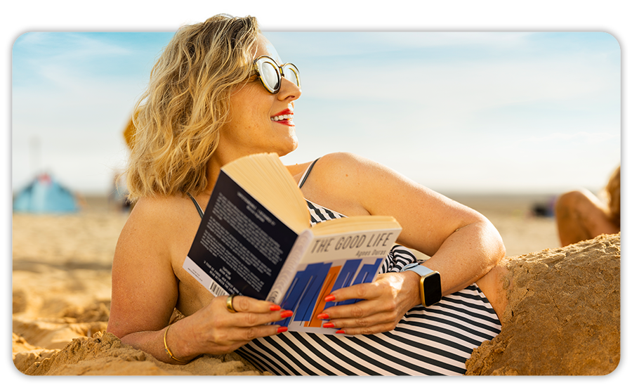 Image of a woman reading on the beach